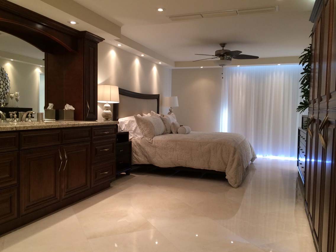 A bedroom with a large bed and a ceiling fan