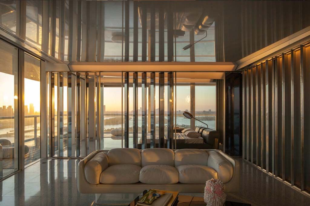 A living room with a couch and a lot of windows.