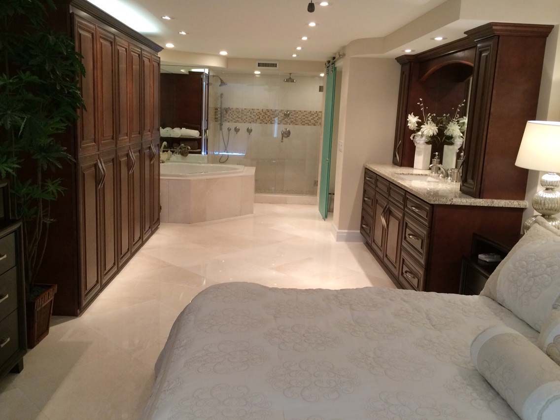 A bedroom with a large bed and a walk in shower