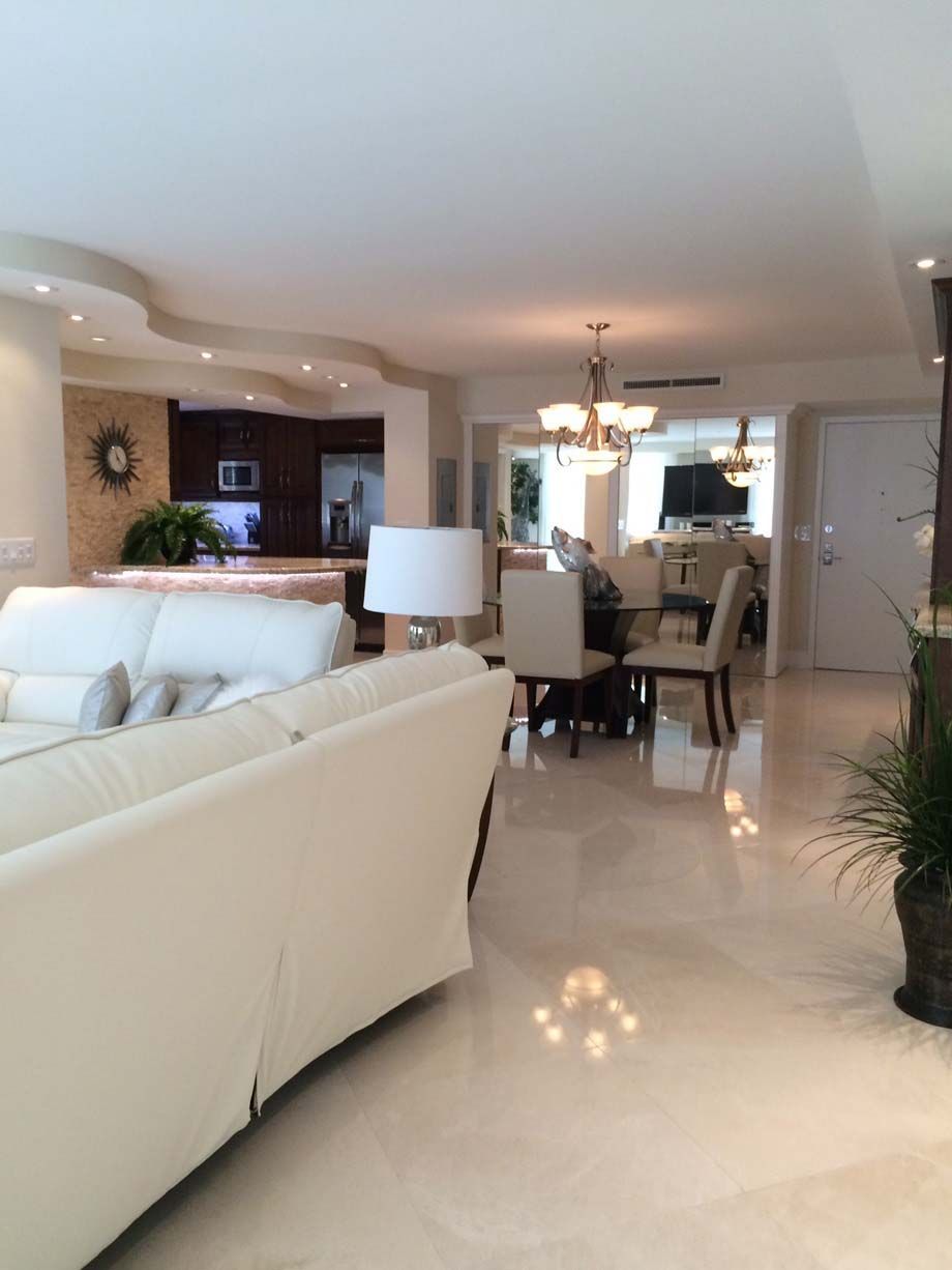 A living room with a white couch and chairs