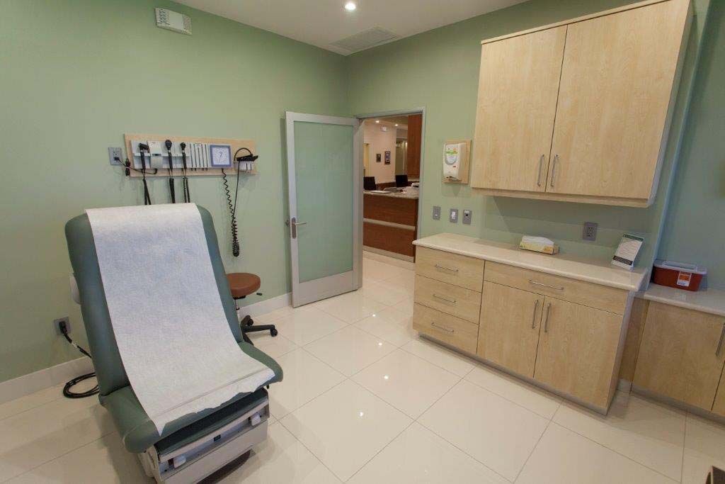 A doctor 's office with a examination table and a stethoscope.