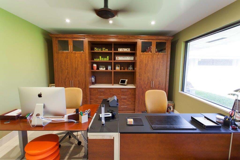 A home office with two desks and a computer