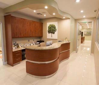 A dental office with a curved counter and a painting of a tree on the wall.