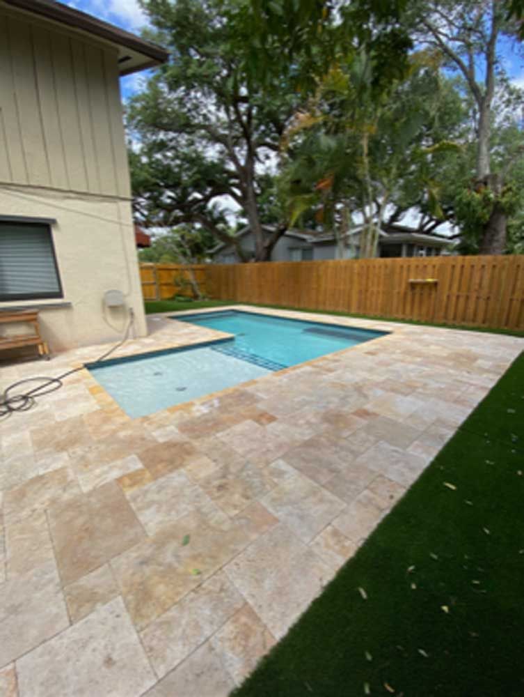 There is a swimming pool in the backyard of a house.