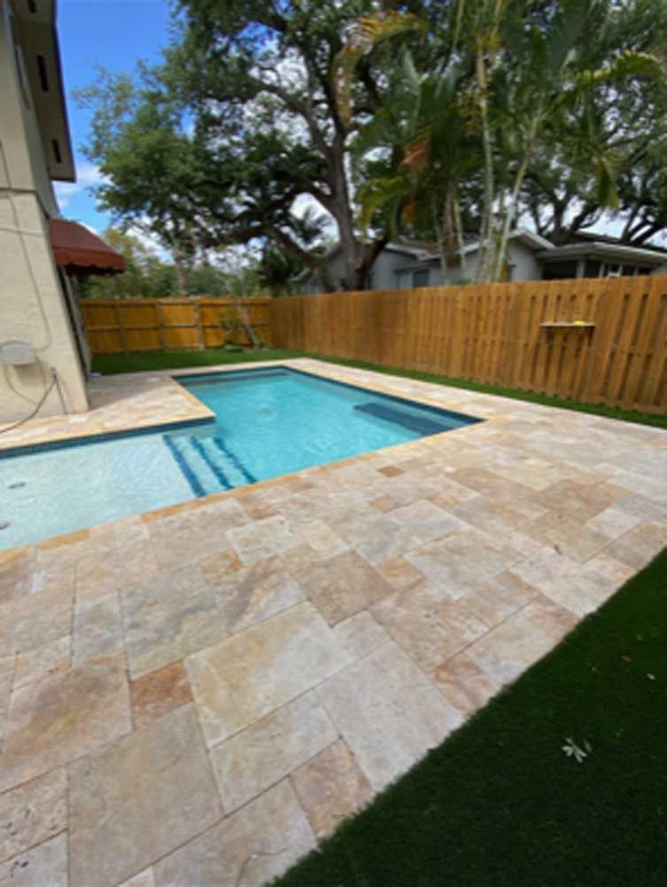 There is a large swimming pool in the backyard of a house.