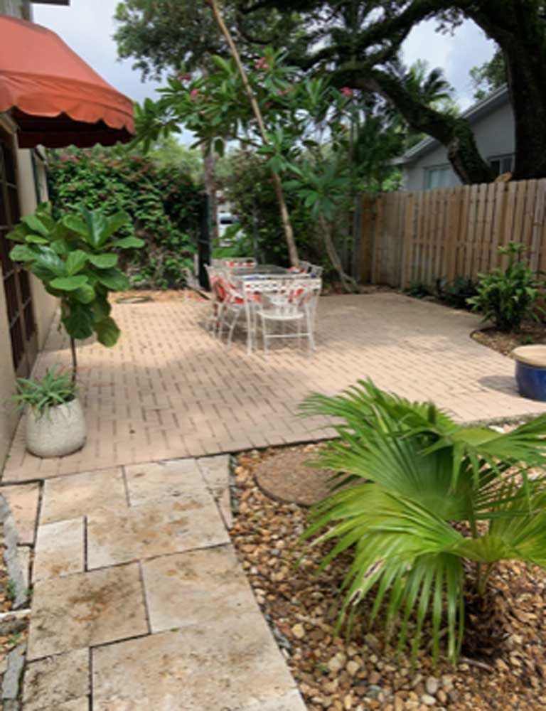 A patio with a table and chairs and a red awning.