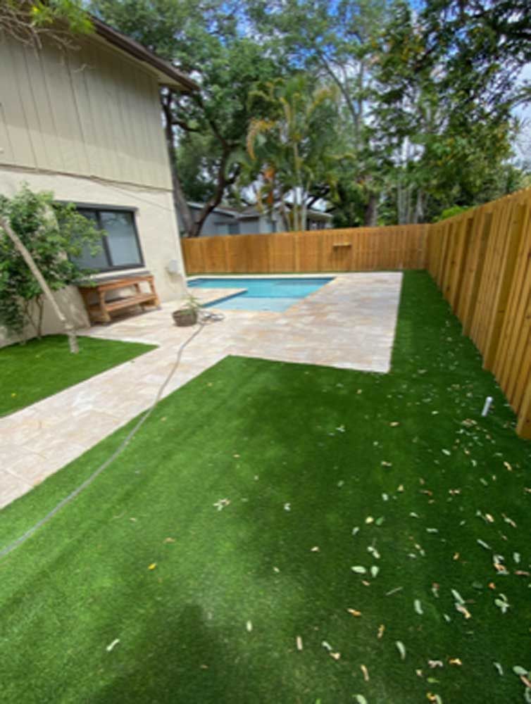 A backyard with a swimming pool and a wooden fence.