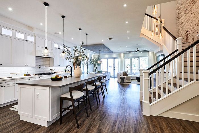 A kitchen with a large island and stairs leading up to the second floor.