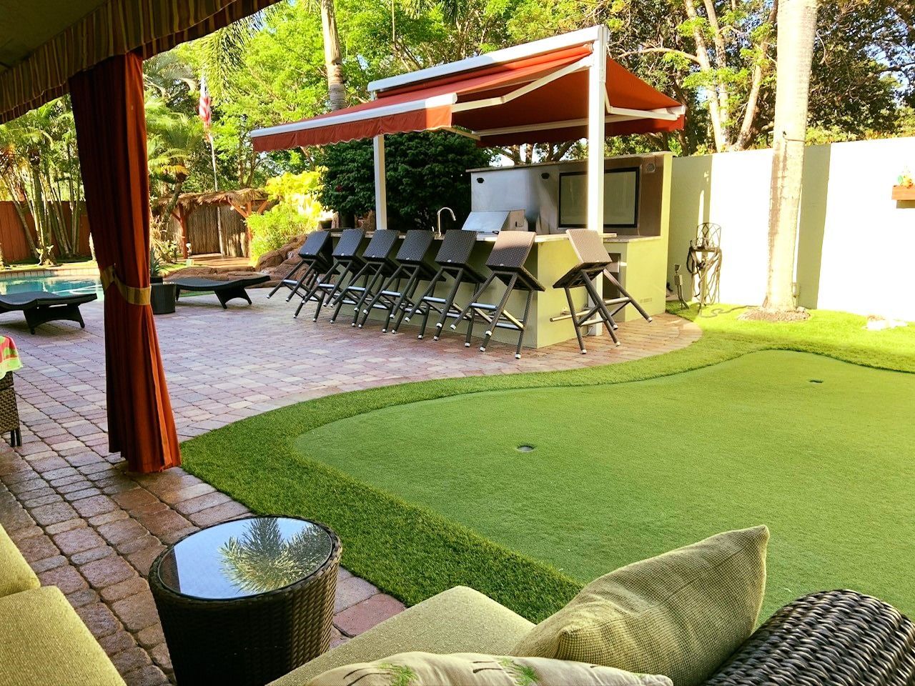 A backyard with a patio area and a putting green