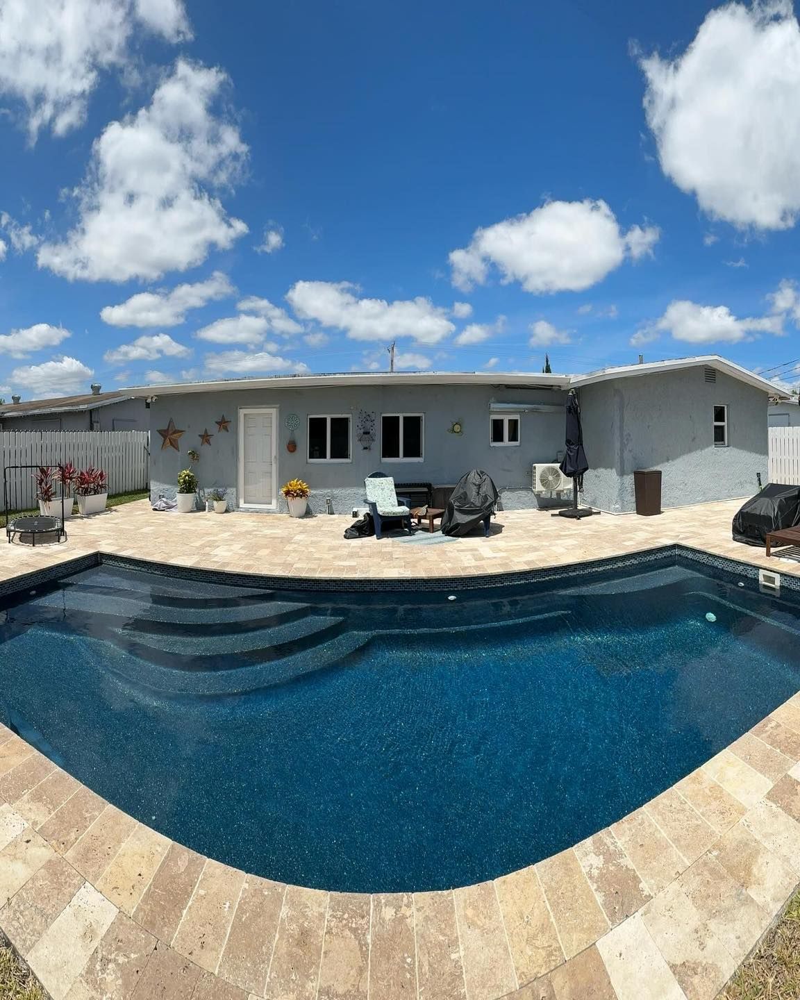 A house with a large swimming pool in front of it