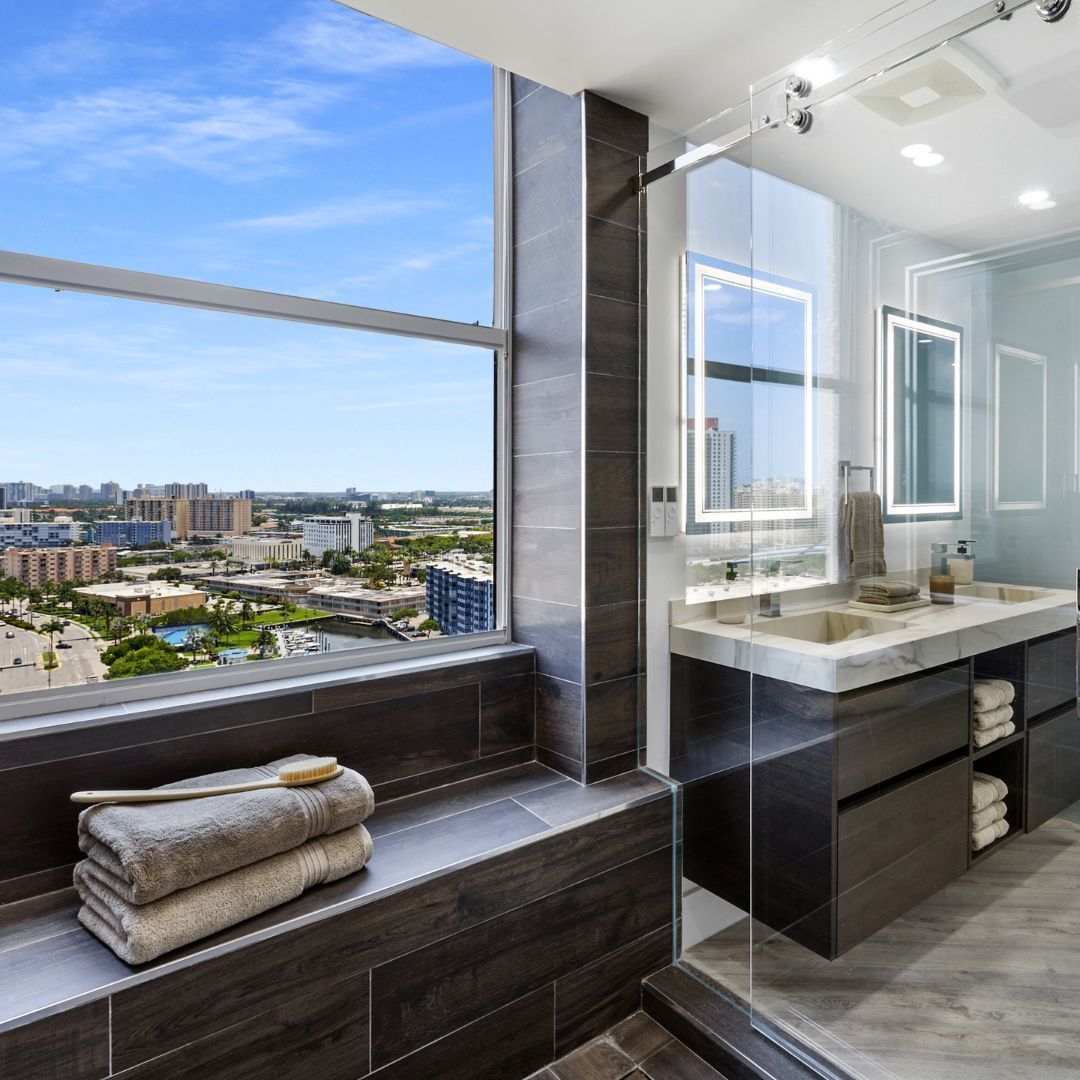 A bathroom with two sinks and a large window with a view of the city.