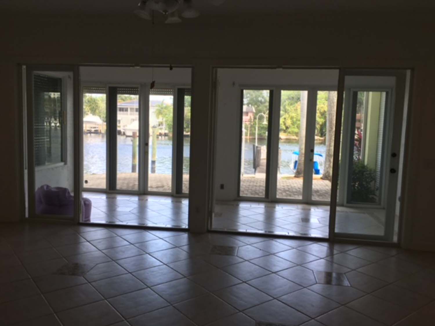 An empty room with a lot of windows and a view of the water.
