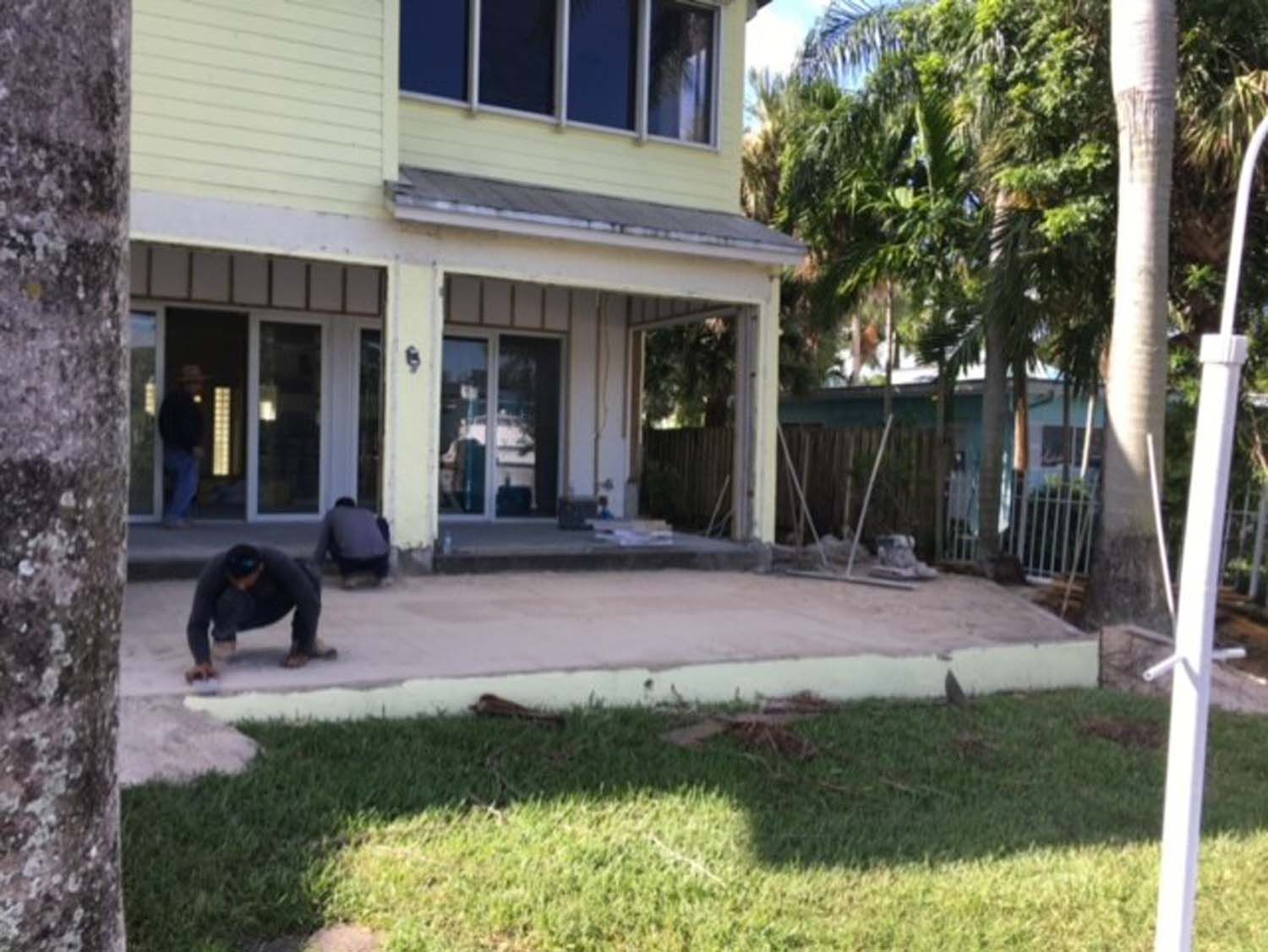 A man is doing a handstand in front of a house.