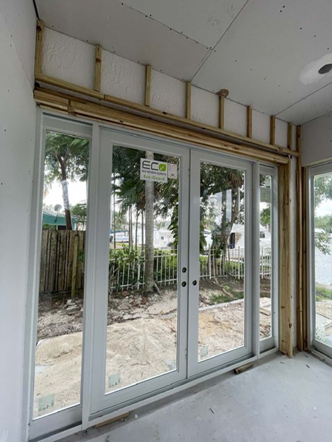 A room with a lot of windows and a fence in the background.