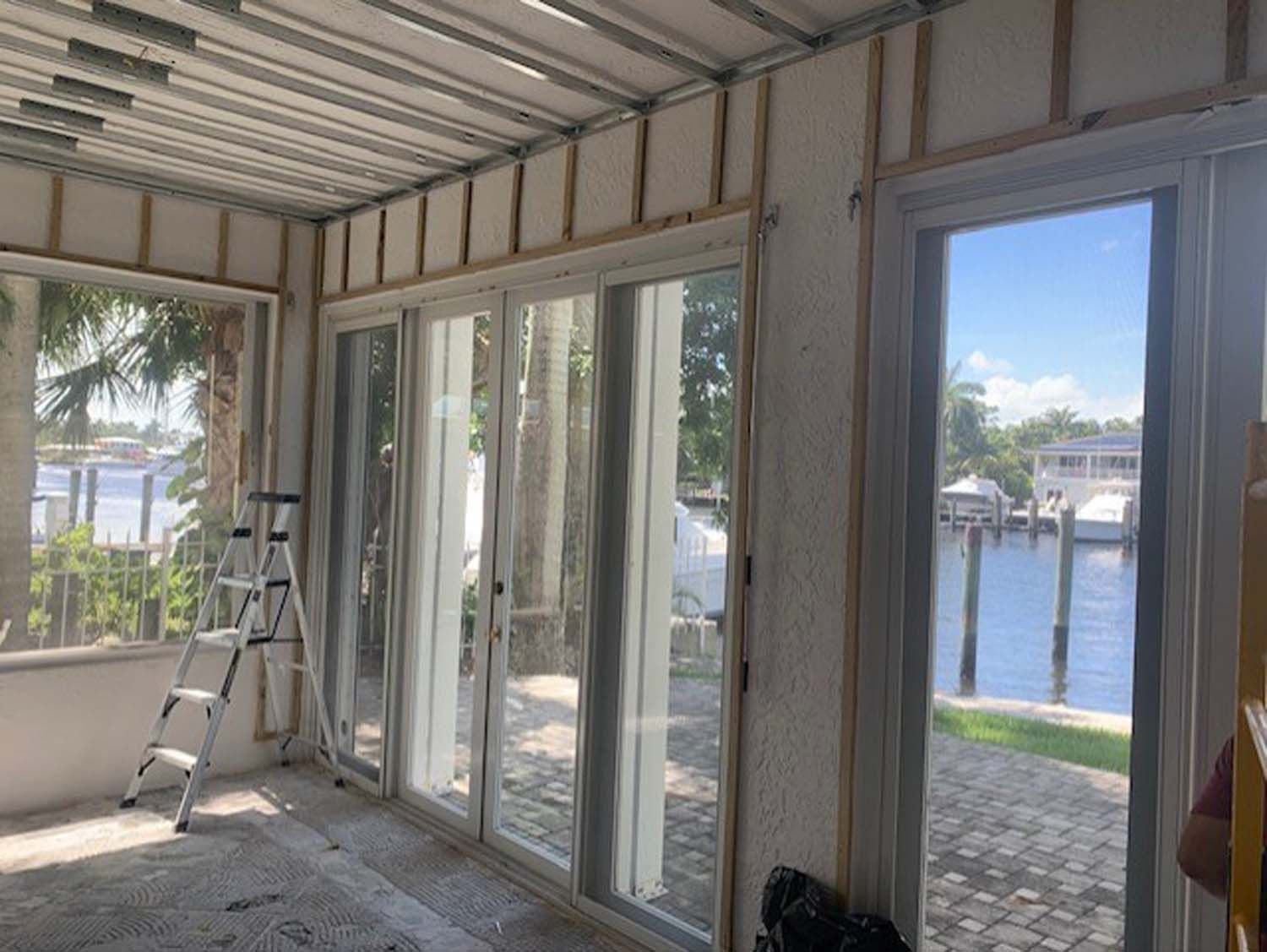 A room with a lot of windows and a ladder in it.