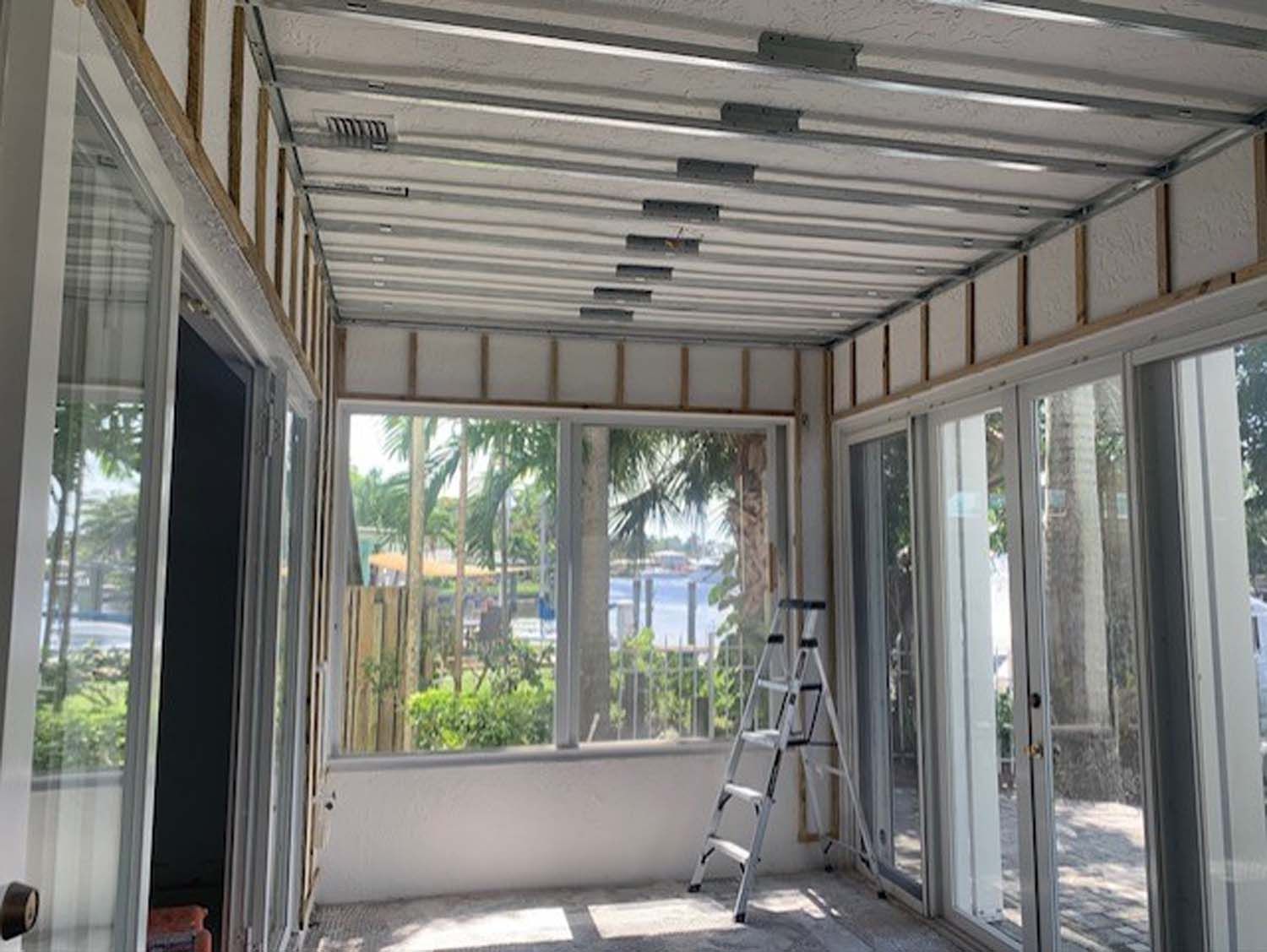 A room with a lot of windows and a ladder in it