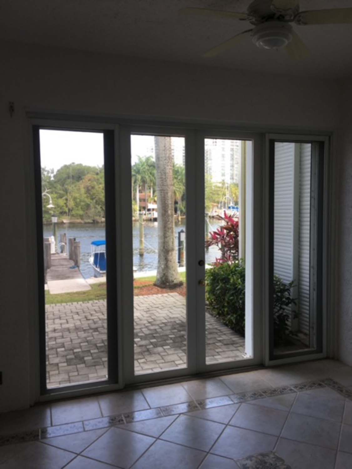 A room with a lot of windows and a view of a body of water.