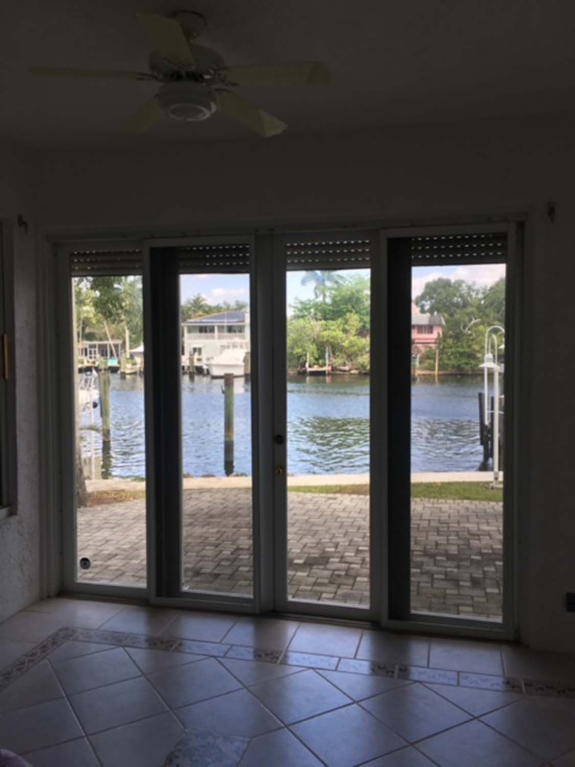 A room with sliding glass doors looking out to a body of water