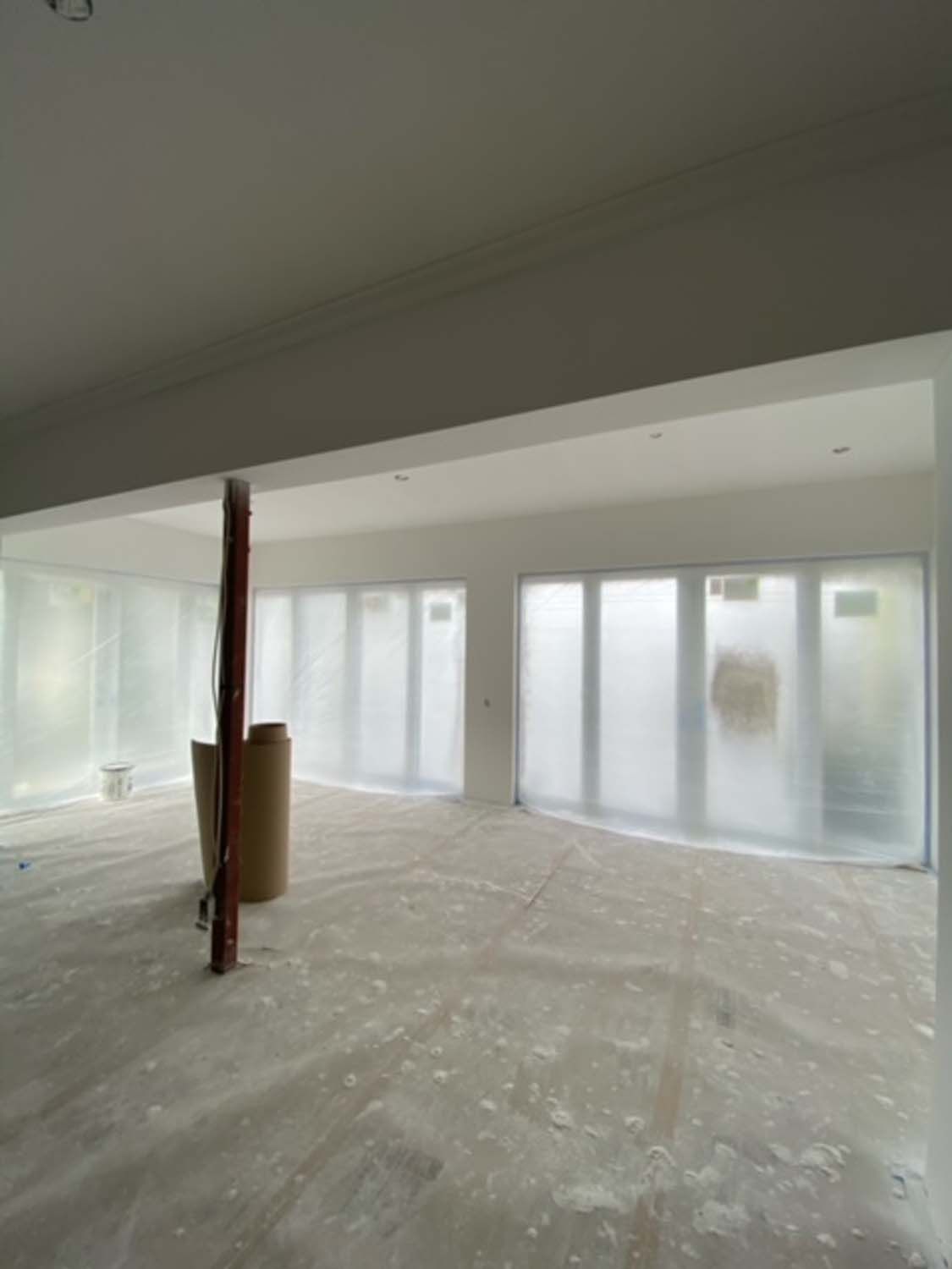 An empty room with a lot of windows and a pillar