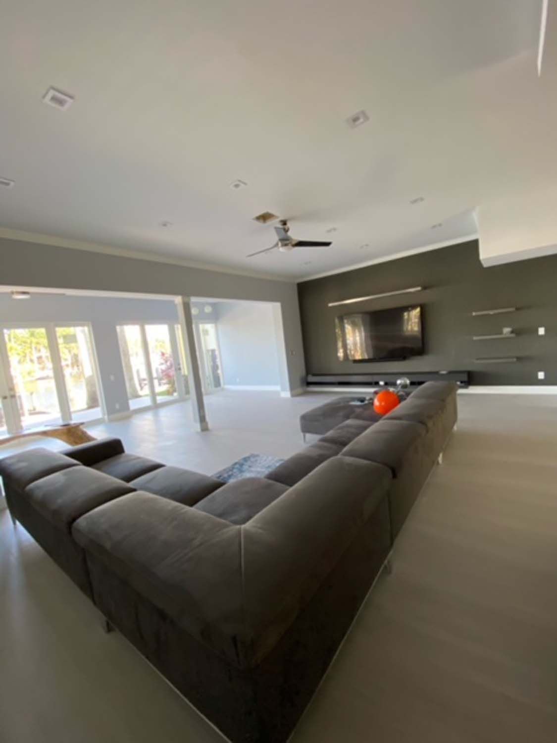 A living room with a large sectional couch and a flat screen tv.