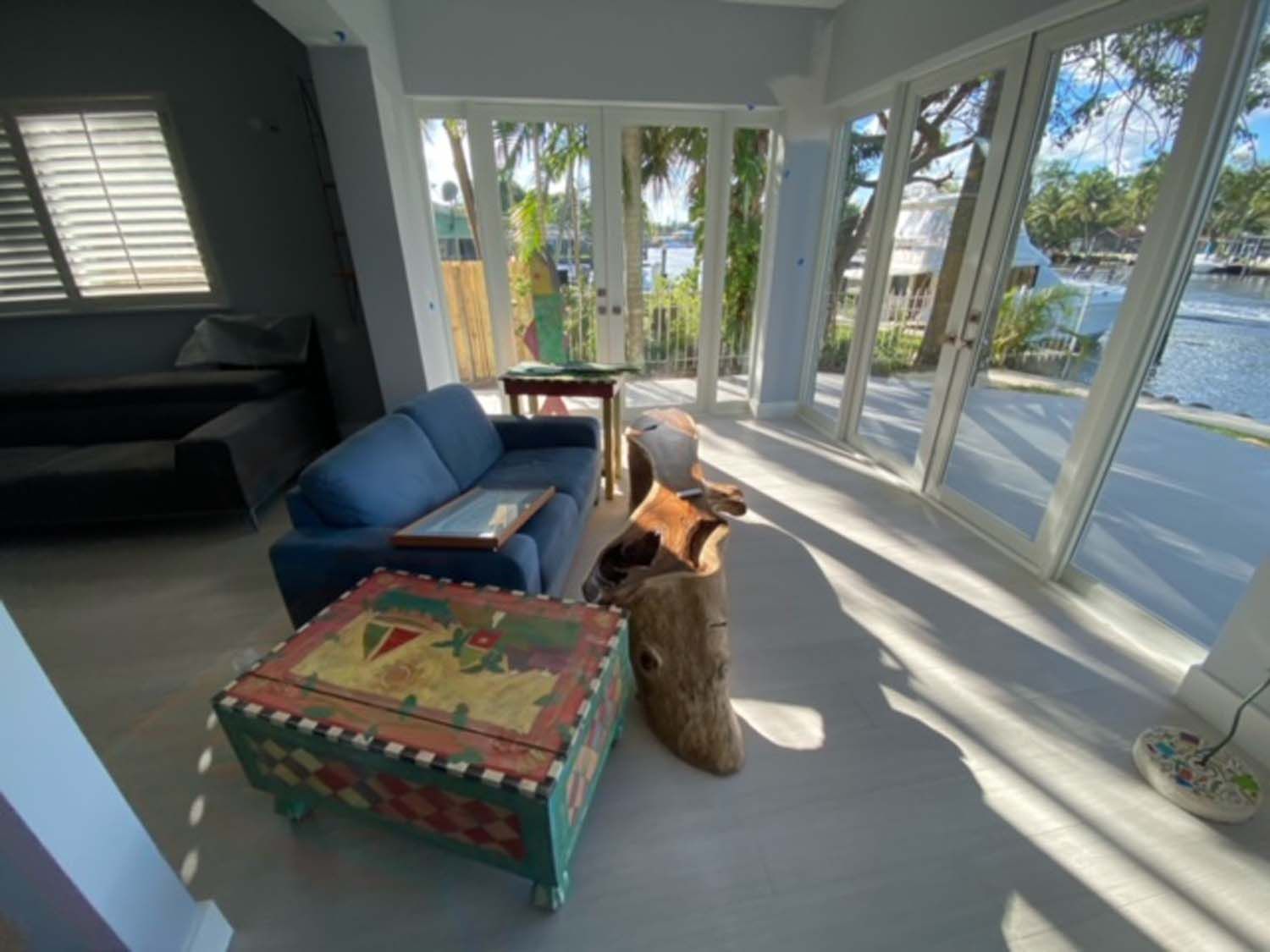 A living room with a blue couch and a colorful coffee table