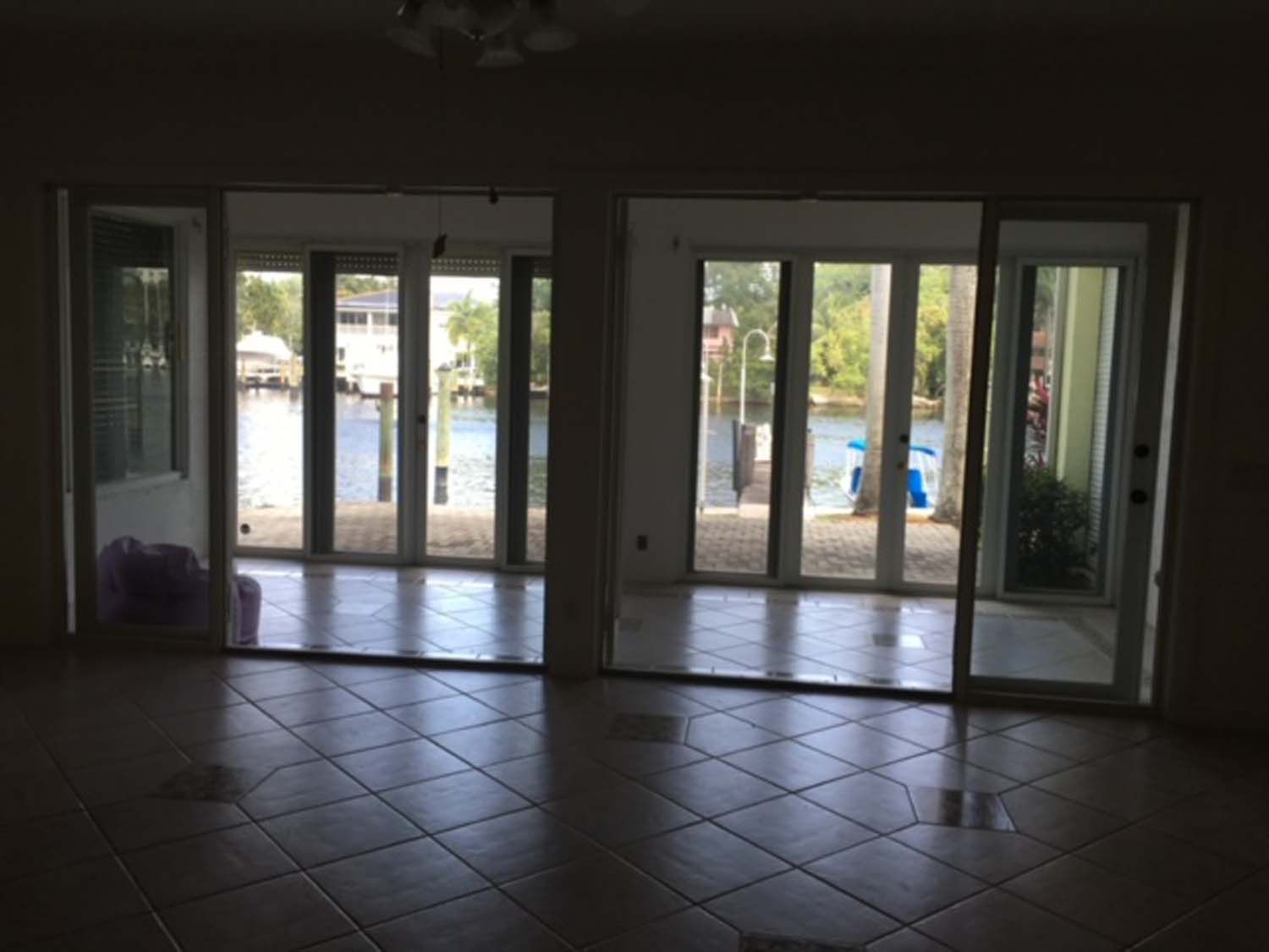 An empty room with a lot of windows and a view of a body of water