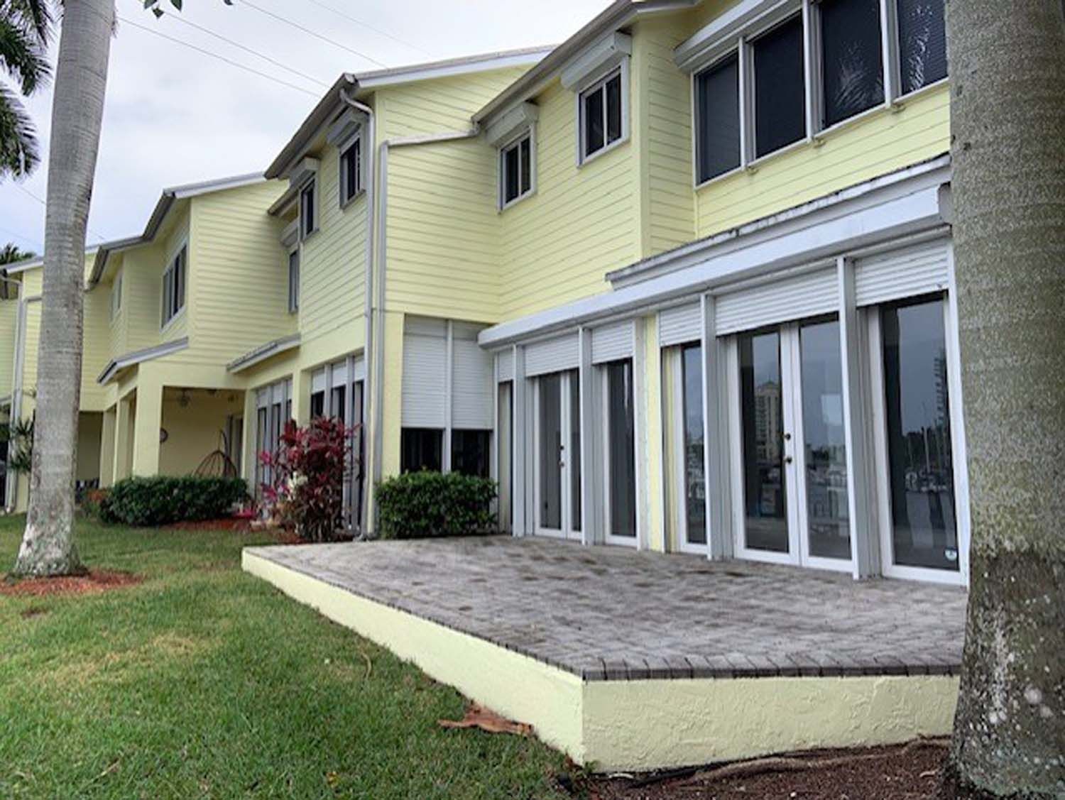 A yellow house with a patio in front of it
