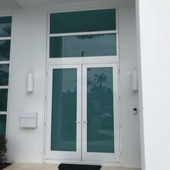 A white house with a large door and a mailbox