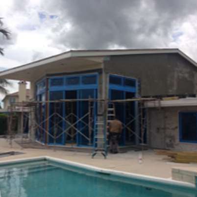 A house under construction with a pool in front of it