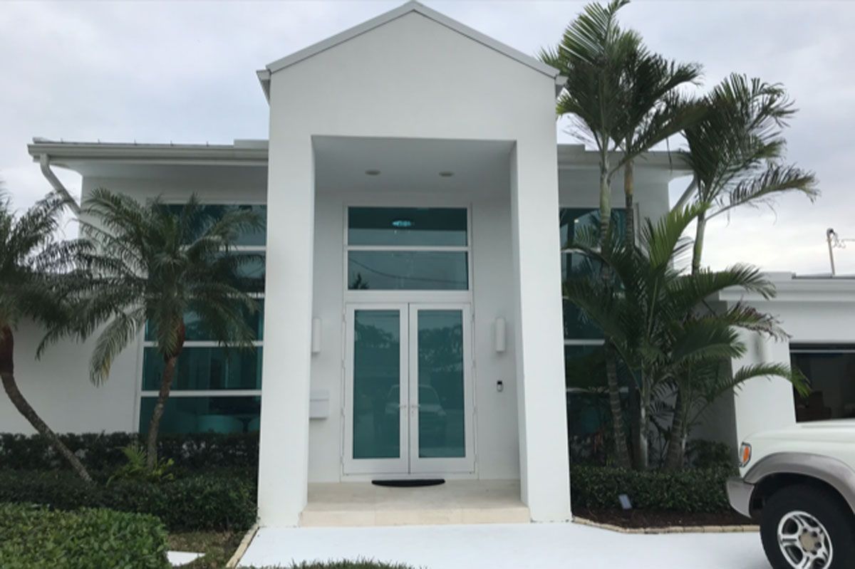 A white house with a car parked in front of it.