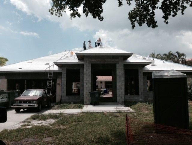 A house that is being built with a red truck parked in front of it