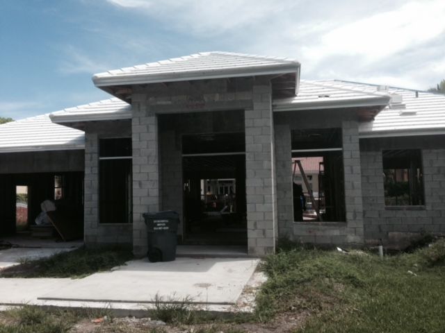 A house that is being built with a trash can in front of it