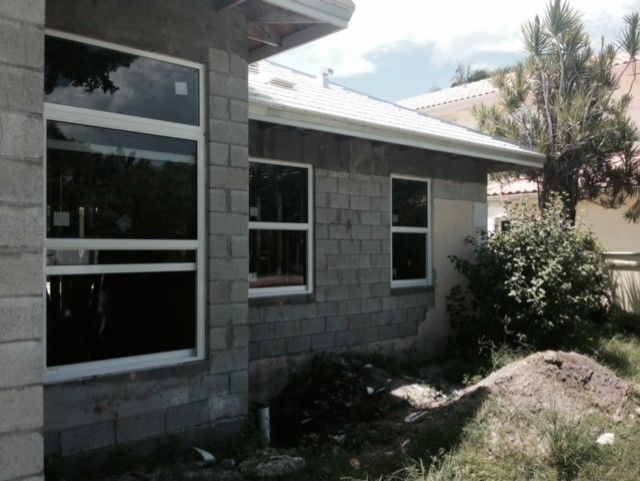 A brick house with a lot of windows and a pile of dirt in front of it