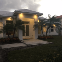A white house with palm trees in front of it