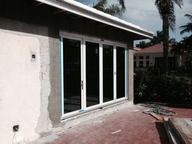 A house with a lot of windows and a palm tree in the background