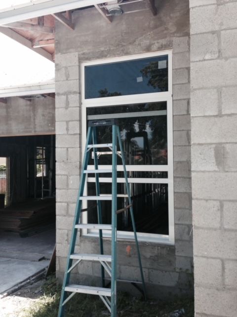 A ladder is sitting in front of a window on a brick building