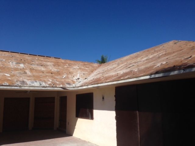 A house with a brown roof and a blue sky in the background
