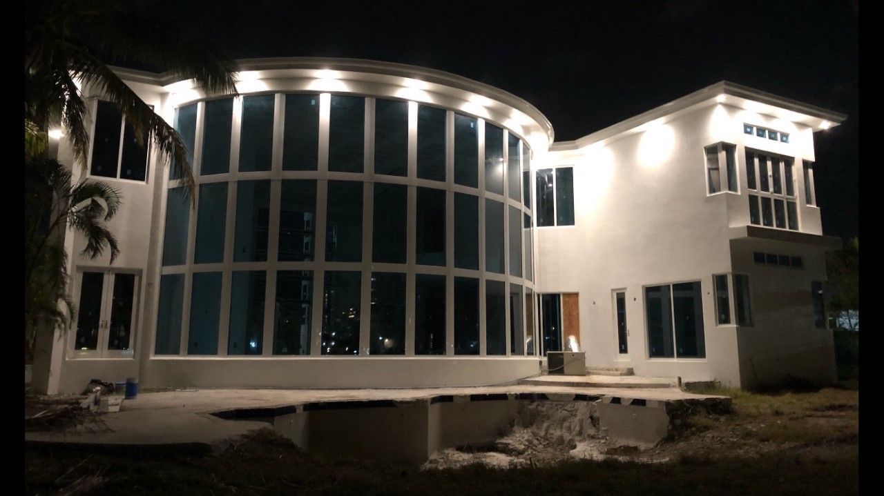 A large white house with a lot of windows is lit up at night