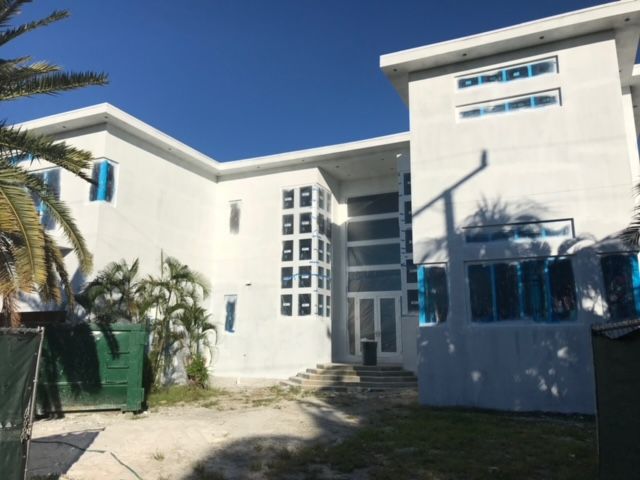 A large white building with a palm tree in front of it