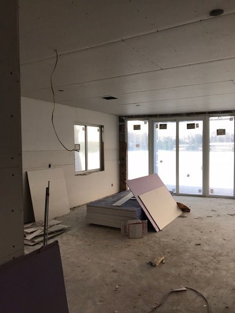 A room with a lot of windows and a mattress on the floor