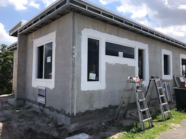 A house with a lot of windows is being painted white.