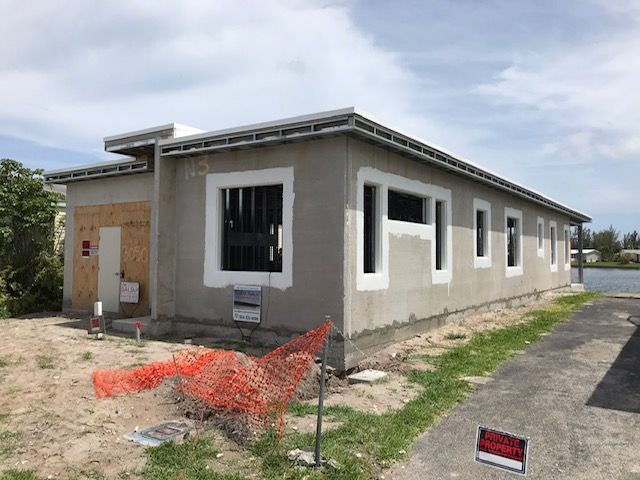 A house is being built next to a body of water.