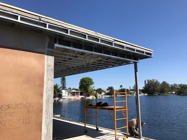 A man is working on a roof overlooking a body of water.