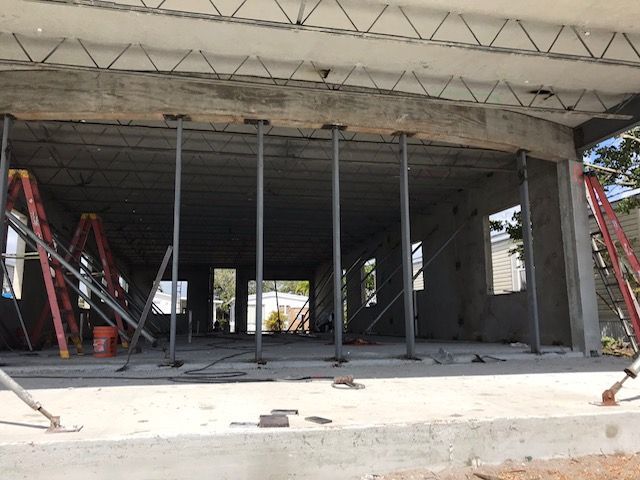 A building under construction with a ladder in the foreground.