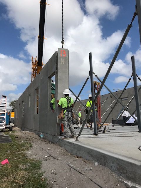 A crane is lifting a concrete wall with the letter n on it