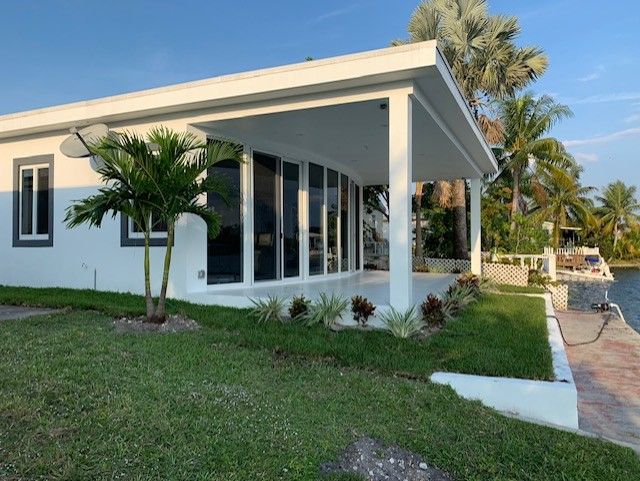 A white house with a large porch and lots of windows