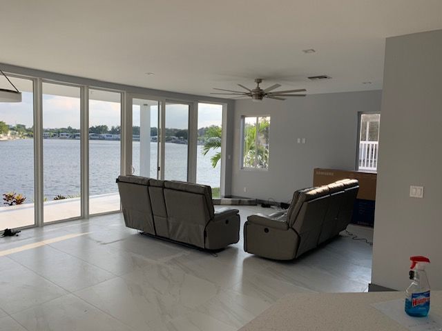 A living room with a couch and chairs and a view of the water.