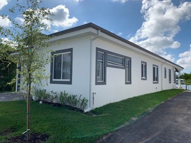 A white house with a tree in front of it