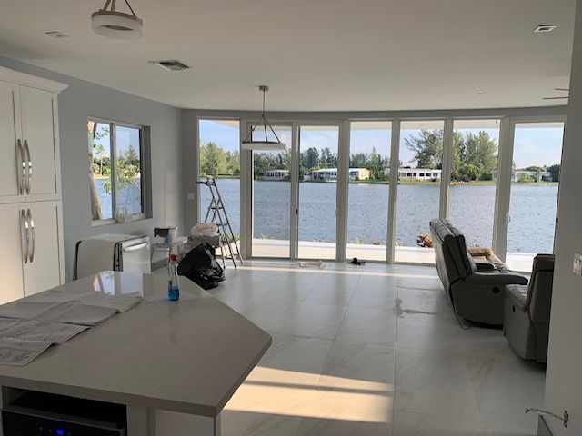 A living room with a lot of windows overlooking a body of water
