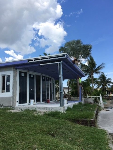 A white house with a purple roof and a porch
